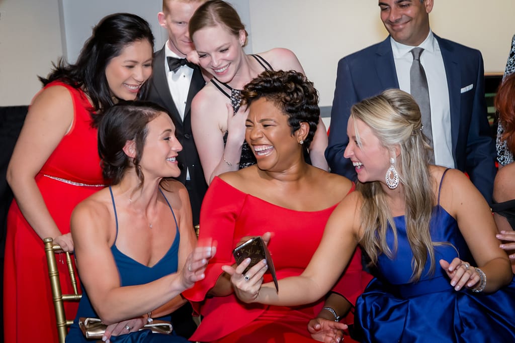 corporate event photograph 01 - atlanta's commercial photographer an image of women at a corporate event sharing a laugh with a cell phone photographed by atlanta commercial photographer karen images