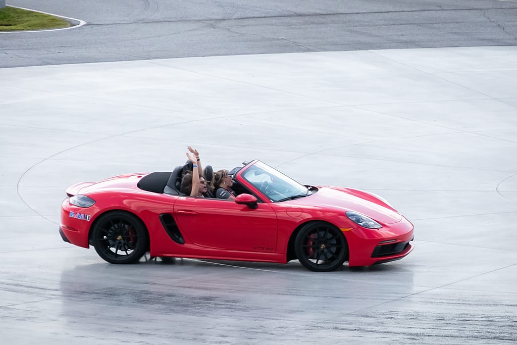 pcna oktoberfest 2022_pre release images_karenimages 2022 - 25 - atlanta's commercial photographer an image of guests in a red porsche on the turn table at a corporate event at one porsche drive photographed by corporate event photographer karen images